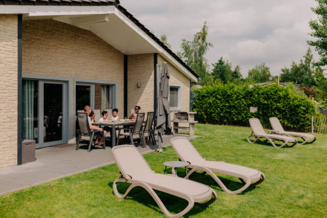 Terrasse mit hochwertigen Sitzmöbeln, Grill und Sonnenschirm, Relaxliegen mit Beistelltisch